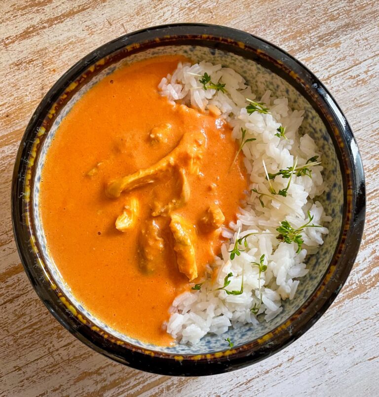 Indisches Butter Chicken mit Reis in einer Schale